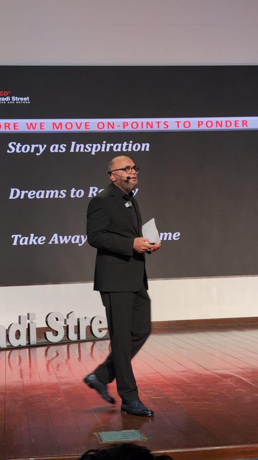 Masood speaking on stage at TEDxAzadiStreet